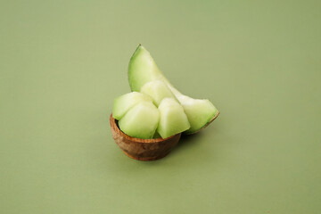 Green cantaloupe melon with cut slice isolated on white background, green melon