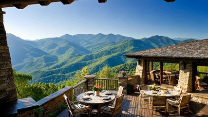 A rustic dining area with a wooden table and chairs overlooks a stunning mountain range