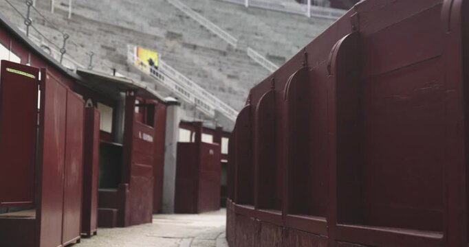 Beautiful slow motion zoom in shot from inside and the benches of the bullring in Las Ventas, Madrid without people during a summer day.