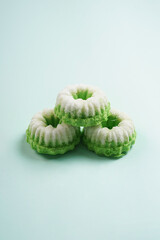Putu ayu isolated on green background. It is a traditional dessert made from steamed rice flour and topped with grated coconut, a classic Indonesian cake
