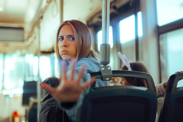 Woman Sitting in Public Transportation Setting Personal Boundaries. Annoyed bothered lady setting limits for her personal space in a bus 