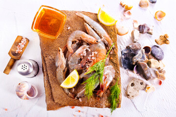 Raw tiger white shrimp prawn on board with herbs.