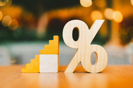 Percent symbol and wooden model connected to form a ladder concept of progressive taxation, insurance or savings with annual dividend payment in a progressive manner.