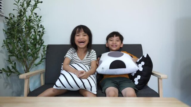 Family, children and sister and brother relax on a sofa, happy and laughing in their home together. Portrait, kids and siblings bond in a living room,