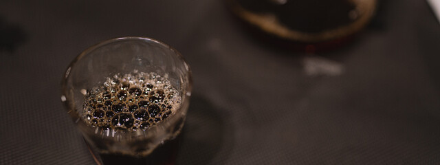 In a closeup of bustling cafes, the barista prepared a hot drink, the fresh aroma wafting through the air as bubbles danced in the steaming cup, inviting all to indulge.