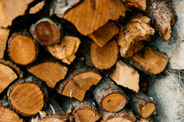 Rustic pile of firewood stacked in front of brick wall background