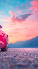 A red car parked on a scenic road at sunset with mountains in the background.