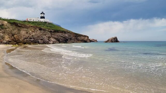 View on lighthouse and wavy beach at Africas northernmost point Cap Angela on a cloudy day Tunisia