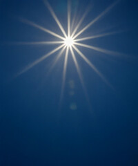 Fototapeta premium Sunbeam through the haze on blue sky, vertical