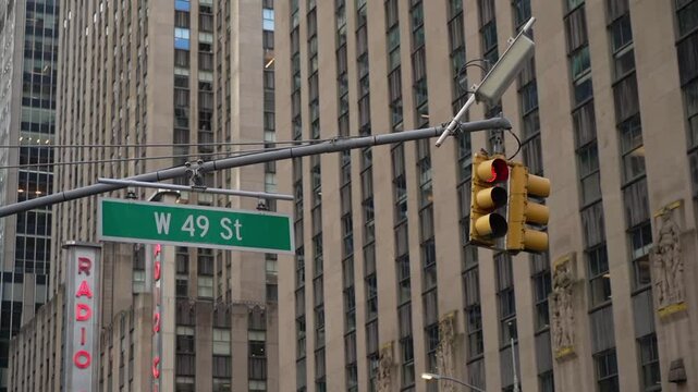 A vibrant and bustling street scene, prominently featuring a traffic signal and the W 49th St sign, located in the heart of Midtown Manhattan, beautifully showcasing dynamic urban landscape New York