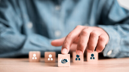 hand shaking icon on wooden cube blocks and human in circle icon for business deal concept. Teamwork process of partner, best relationship. For business contract,