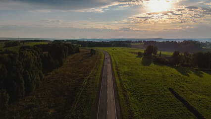 Fototapeta premium dawn over the road on which the car is traveling