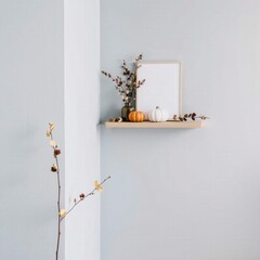 Minimalist Autumn Decor: Light Wood Shelf with White Pumpkin and Dried Branches against Light Blue Wall
