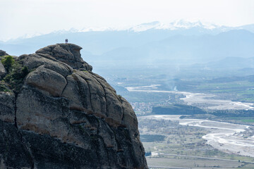 man and woman standing at edge of mountain watching the amazing view