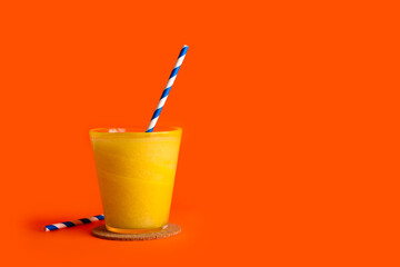 Glass of tasty melon smoothie on orange background