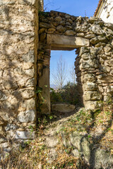 Passage in the stone wall of a medieval fortress on top of a cliff. Sunlight, shadows