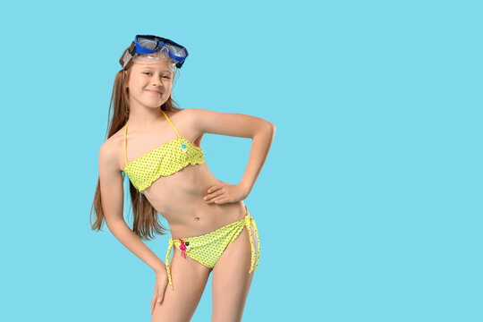 Fototapeta Cute little happy girl in swimsuit with snorkeling mask on blue background