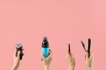 Female hands with straight razor, electric shaver, bottle of cosmetic product and razor on pink...