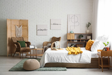 Interior of bedroom with armchairs, breakfast and books on bed