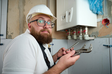 Plumber Install Boiler.Professional engineer installing gas boiler at home and checking the...