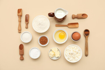 Different ingredients for preparing sweet cinnamon roll on beige background