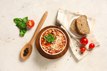 Bowl of pasta fagioli with ingredients and slices of bread on white background