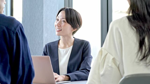 笑顔で話をするスーツを着た女性