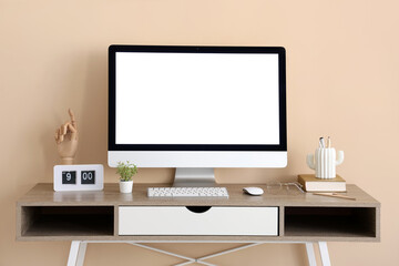 Stylish workplace with modern computer, clock and stationery near beige wall in office