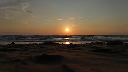 Serene beach sunset with gentle waves.