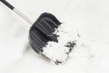 Black shovel snow clean snow. Selective focus.