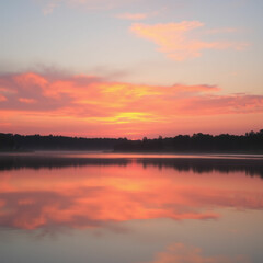 Obraz premium A tranquil lake reflecting a sunset with vibrant hues