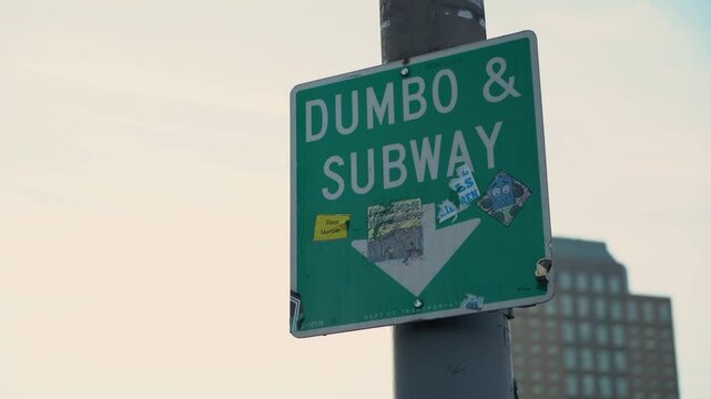 An eyecatching, colorful urban sign directing visitors towards DUMBO and providing subway access in the bustling city
