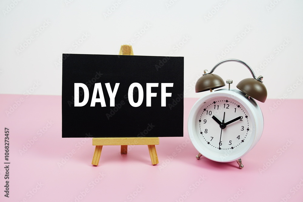 Poster day off text on paper card with alarm clock on pink background