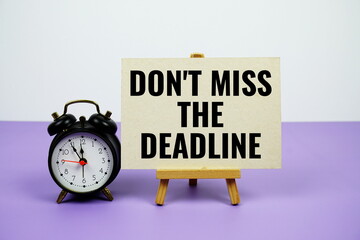 Don't miss the deadline text on paper card with alarm clock on purple background
