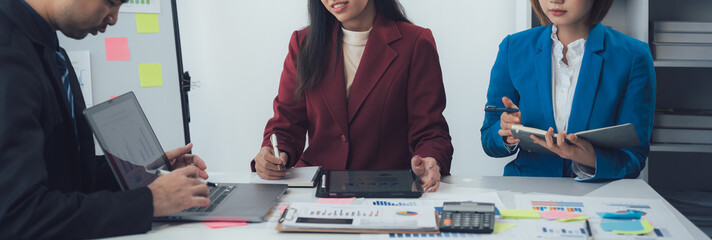 Business Collaboration: A diverse team of professionals engages in a collaborative brainstorming session, focusing on a shared goal. They utilize various tools, including laptops, tablets.