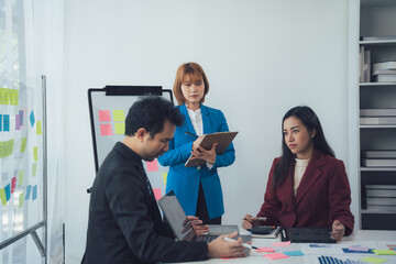 Business Meeting: A team of professionals engaged in a productive meeting, focused on their tasks and ideas. The image captures the essence of collaboration and brainstorming in a modern workspace. 