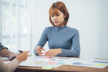 Focused Collaboration: A young businesswoman deeply engrossed in a collaborative project,...