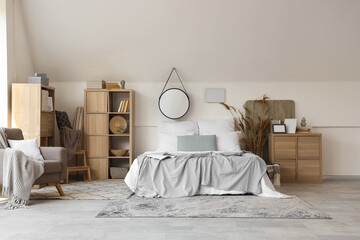 Comfortable modern bedroom with armchair and mirror