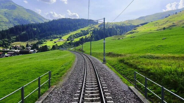 Rear View From the Glacier Express Train on Railroad Tracks in a Sunny Summer Day in Sedrun, Surselva, Oberalp, Grisons, Switzerland.