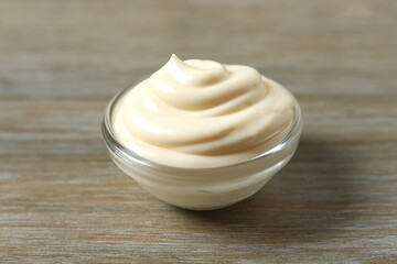 Bowl with mayonnaise on wooden background