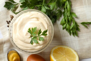 Bowl with mayonnaise and ingredients for cooking on wooden background