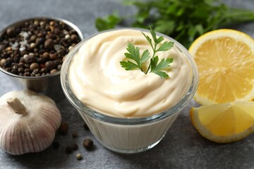 Bowl with mayonnaise and ingredients for cooking on gray background