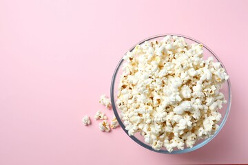 Delicious popcorn in a bowl on a color background