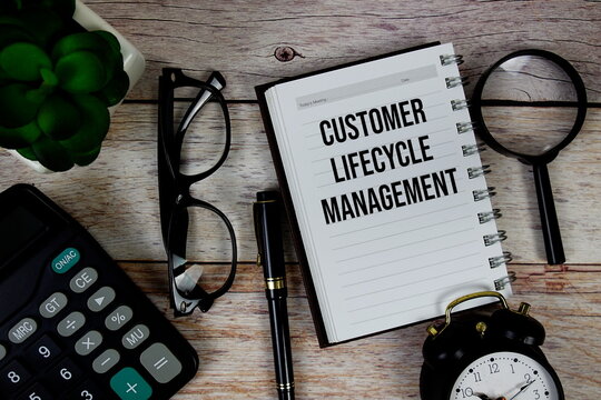 Customer Lifecycle Management (CLM) text on notepad, Business and Financial concept background