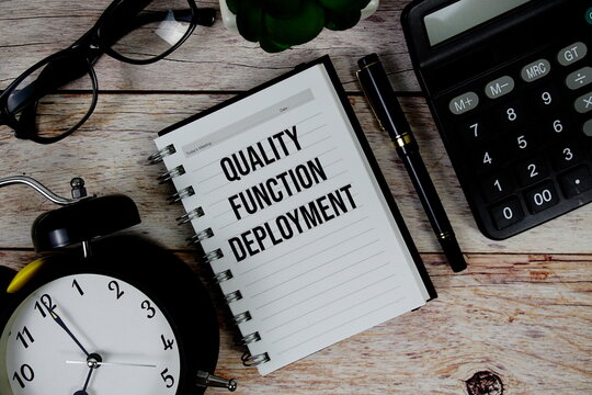 Quality Function Deployment (QFD) text on notepad, Business and Financial concept background