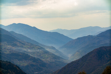 A scenic valley surrounded by tall mountains and lush trees