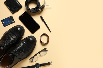Stylish men's accessories with shoes and modern mobile phone on beige background