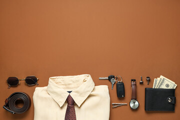 Stylish men's accessories with shirt and car key on brown background