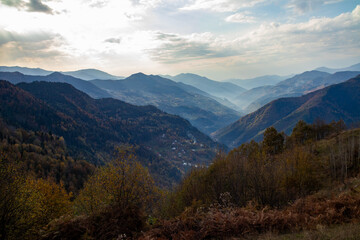 A valley view surrounded by mountains on a cloudy day