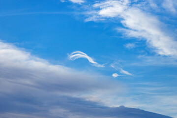 Blue sky background. A white cloud in the blue sky